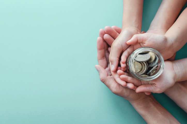 hands holding jar of coins