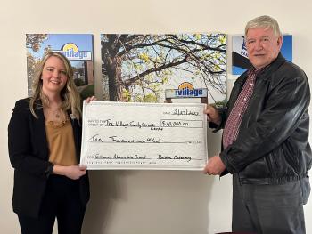 Roger Thalman from the Alexandria City Council presents check to Regional Program Supervisor Kristin Goracke.