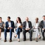 Diverse group of coworkers sitting in chairs in a line with each other